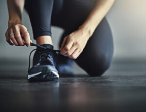 Cropped shot of a woman tying her shoelaces before a workout